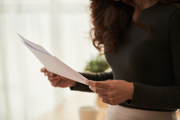 Cropped image of business woman reading documents in her hands